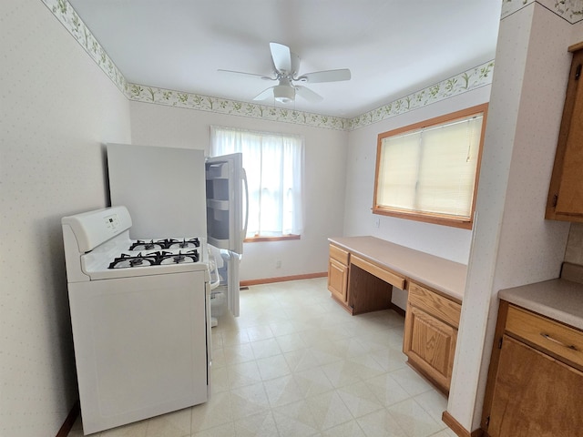 408 Sidney St, Bay City, MI 48706 - kitchen featuring white gas stove, light flooring, ceiling fan, light countertops, and baseboards