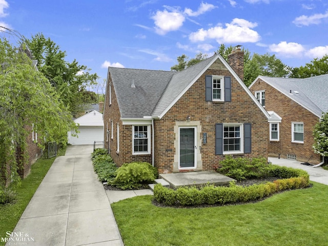 1873 Manchester Blvd, Grosse Pointe Woods, MI 48236 - view of front of house featuring a detached garage, a chimney, brick siding, an outdoor structure, and a front yard