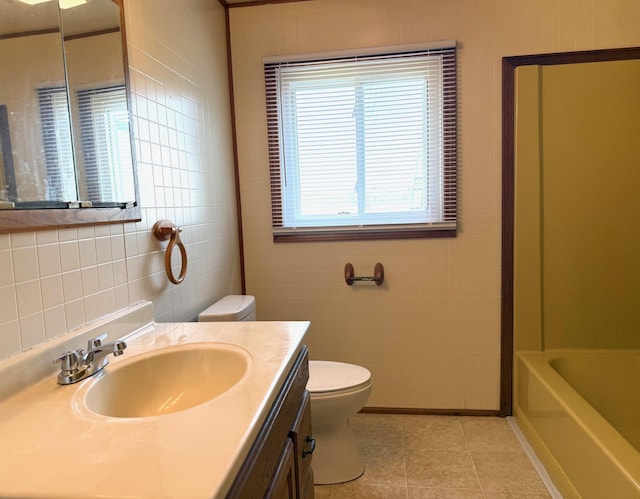7161 W Sterling Rd, Sterling, MI 48659 - full bath featuring toilet, tile patterned flooring, tile walls, a bathtub, and vanity
