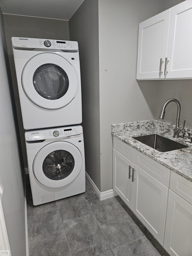 5573 Branch St, Sterling Heights, MI 48310 - laundry area with stacked washer / drying machine, baseboards, and cabinet space