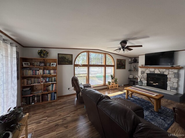 93 E Johnson Lake Rd, Gwinn, MI 49841 - living area featuring a ceiling fan, wood finished floors, a stone fireplace, lofted ceiling, and crown molding