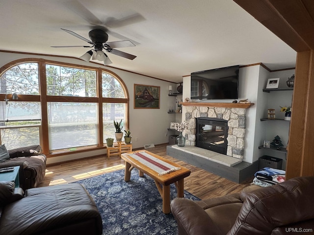 93 E Johnson Lake Rd, Gwinn, MI 49841 - living room featuring crown molding, a ceiling fan, wood finished floors, lofted ceiling, and a stone fireplace