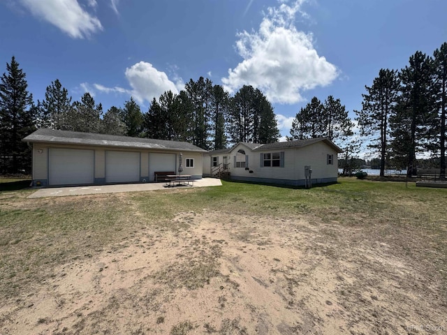 93 E Johnson Lake Rd, Gwinn, MI 49841 - back of property with a garage, a lawn, and a patio
