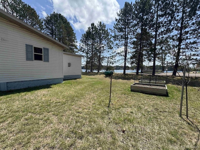 93 E Johnson Lake Rd, Gwinn, MI 49841 - view of grassy yard featuring a vegetable garden and a water view