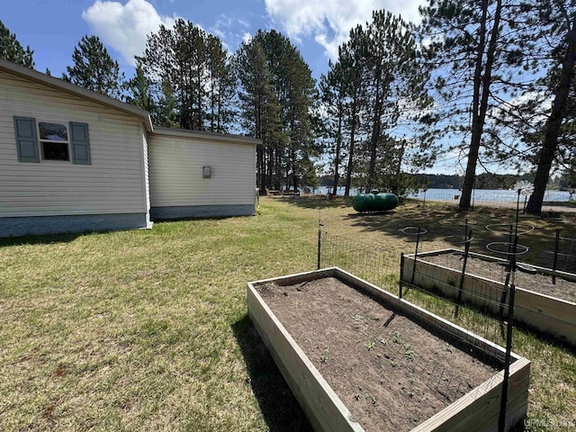 93 E Johnson Lake Rd, Gwinn, MI 49841 - view of grassy yard with a vegetable garden and a water view
