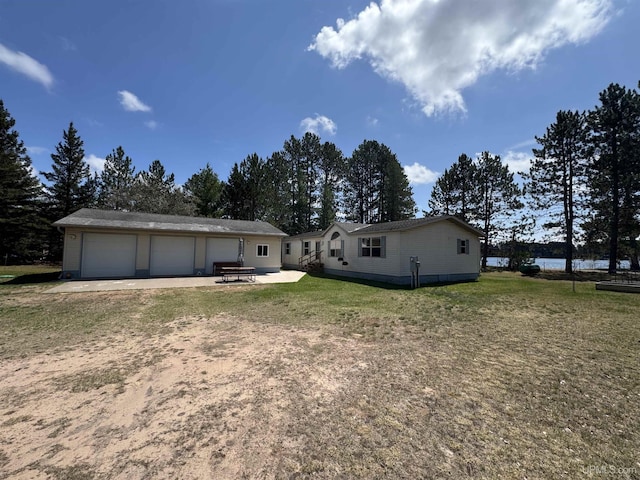 93 E Johnson Lake Rd, Gwinn, MI 49841 - view of front facade featuring a garage, an outbuilding, a water view, a front yard, and a patio