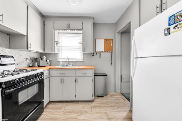 17941 Stephens Dr, Eastpointe, MI 48021 - kitchen featuring freestanding refrigerator, range with gas stovetop, a sink, gray cabinets, and tasteful backsplash