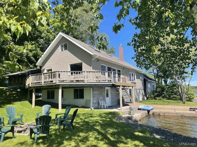 52170 Canal Rd, Houghton, MI 49931 - back of property featuring stairway, a wooden deck, a chimney, a yard, and a fire pit