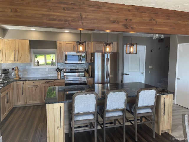 52170 Canal Rd, Houghton, MI 49931 - kitchen featuring appliances with stainless steel finishes, a breakfast bar area, tasteful backsplash, and dark stone countertops