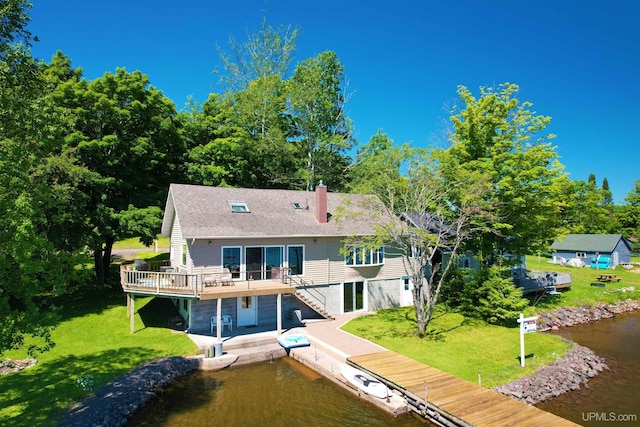 52170 Canal Rd, Houghton, MI 49931 - rear view of house with stairs, a lawn, a deck with water view, and a chimney