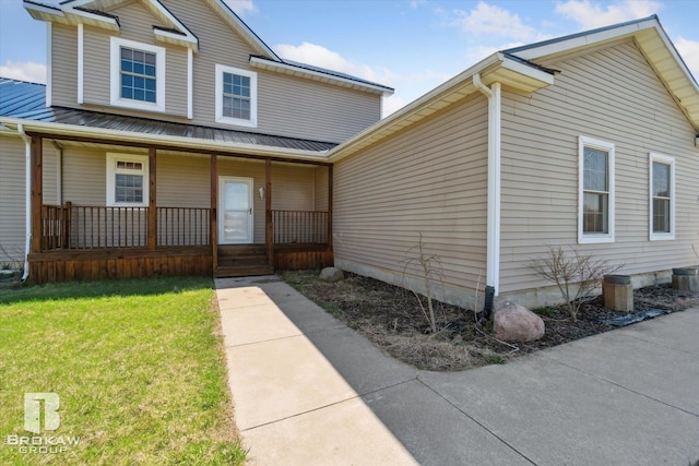 3275 Morrish Rd, Swartz Creek, MI 48473 - view of front of property featuring covered porch, metal roof, a front lawn, and a standing seam roof