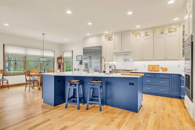 3905 Lakeshore Rd, Lexington, MI 48450 - kitchen featuring stainless steel appliances, light wood-style floors, a kitchen island with sink, light countertops, and recessed lighting