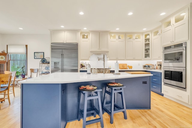 3905 Lakeshore Rd, Lexington, MI 48450 - kitchen featuring appliances with stainless steel finishes, a center island with sink, light countertops, a kitchen breakfast bar, and recessed lighting