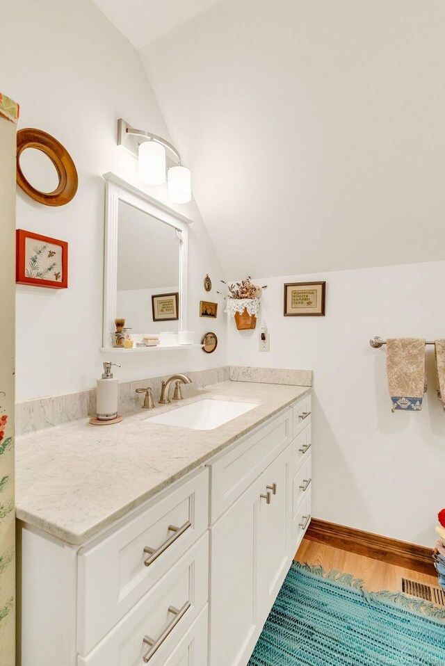 3905 Lakeshore Rd, Lexington, MI 48450 - bathroom featuring lofted ceiling, wood finished floors, vanity, and baseboards