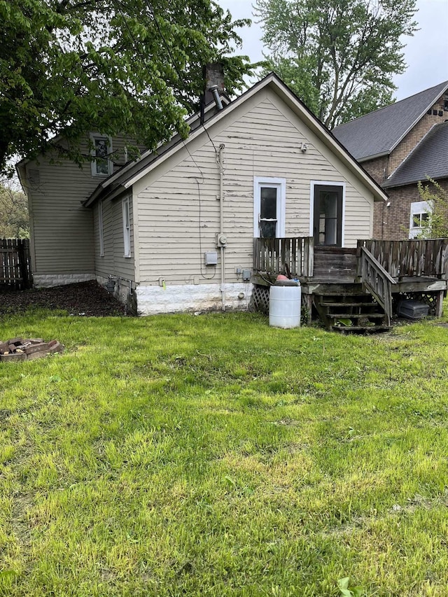 1106 Marsac St, Bay City, MI 48708 - back of property featuring a wooden deck, a yard, and a chimney