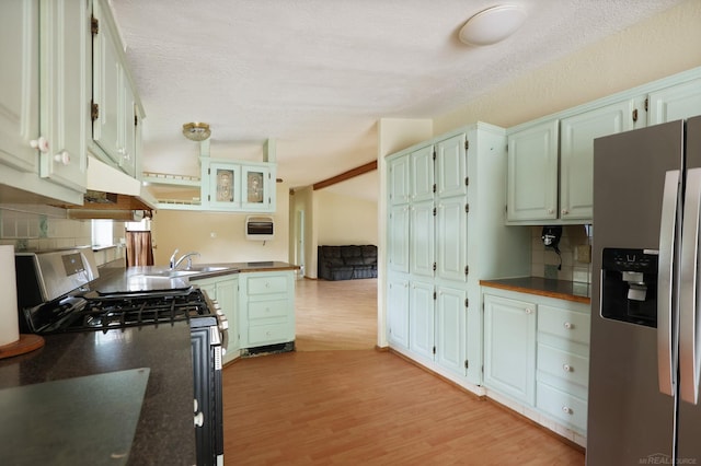 3909 Higgins Rd, Vassar, MI 48768 - kitchen with stainless steel appliances, dark countertops, light wood-style flooring, and tasteful backsplash