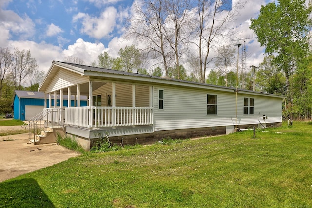 3909 Higgins Rd, Vassar, MI 48768 - view of home's exterior with a porch, a lawn, and an outdoor structure