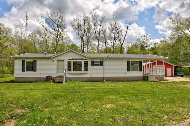 3909 Higgins Rd, Vassar, MI 48768 - back of property with entry steps, a yard, metal roof, and a carport