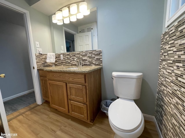 7314 Aspen Rd, Lexington, MI 48450 - bathroom with backsplash, toilet, wood finished floors, and vanity