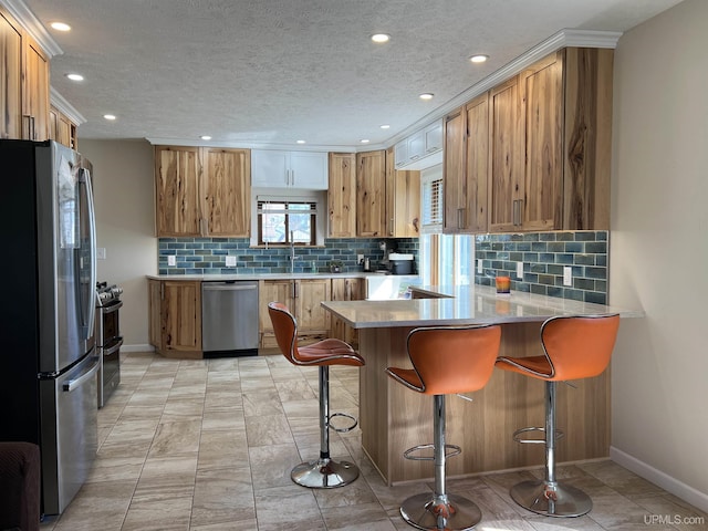 1106 11th Ave, Escanaba, MI 49829 - kitchen featuring appliances with stainless steel finishes, a peninsula, baseboards, backsplash, and recessed lighting