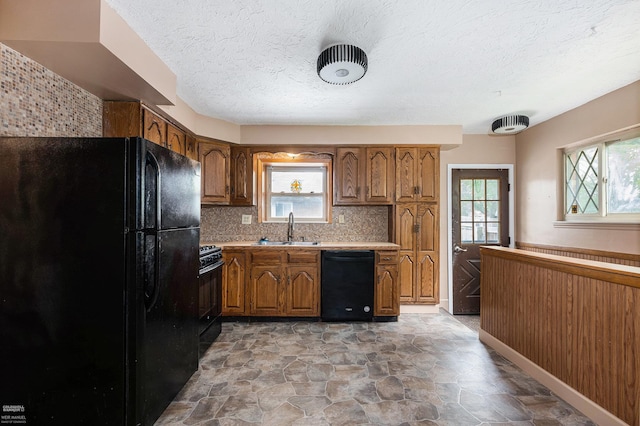 21036 Suffolk St, Clinton Township, MI 48035 - kitchen with black appliances, a sink, brown cabinets, light stone finish flooring, and a textured ceiling