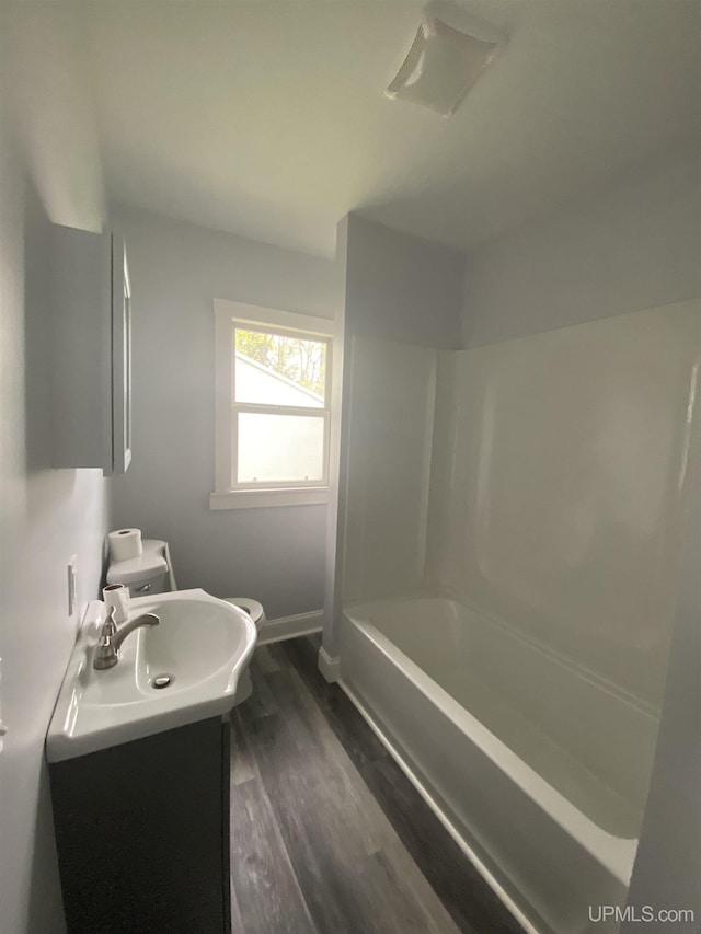 317 Lane Ave, Iron Mountain, MI 49802 - bathroom with wood finished floors, vanity, baseboards, toilet, and shower / bath combination