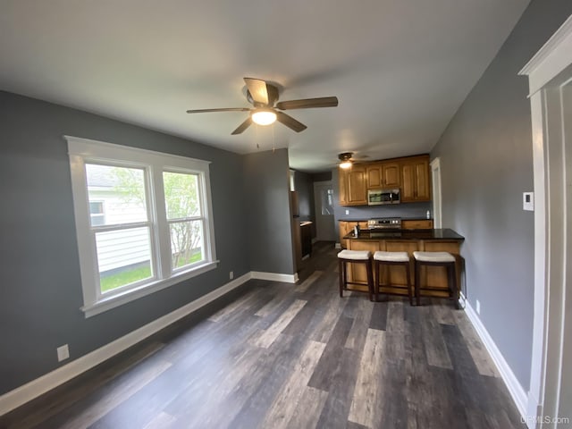 317 Lane Ave, Iron Mountain, MI 49802 - kitchen featuring stainless steel appliances, brown cabinets, dark wood finished floors, dark countertops, and baseboards