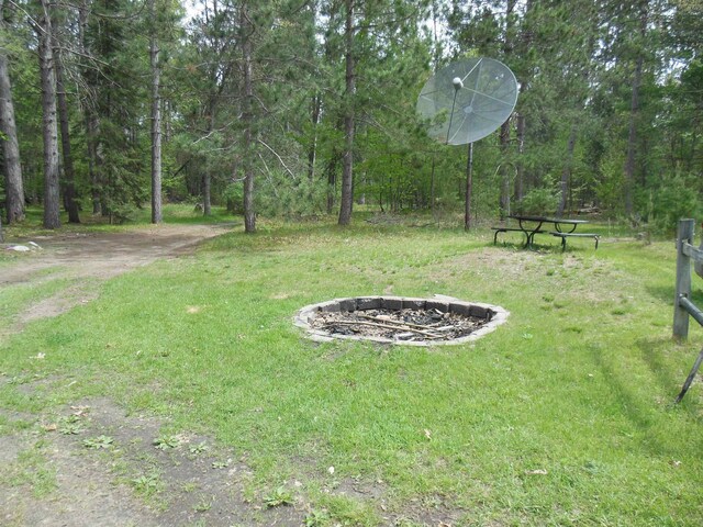 5871 Edith Schneider Rd, Harrison, MI 48625 - view of green lawn featuring an outdoor fire pit and a forest view
