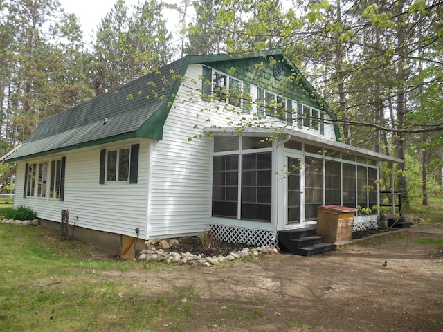 5871 Edith Schneider Rd, Harrison, MI 48625 - back of house featuring a sunroom, entry steps, and a shingled roof
