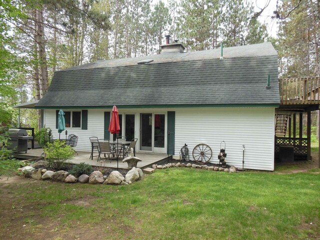 5871 Edith Schneider Rd, Harrison, MI 48625 - back of house with a shingled roof, a yard, a patio, a deck, and a chimney