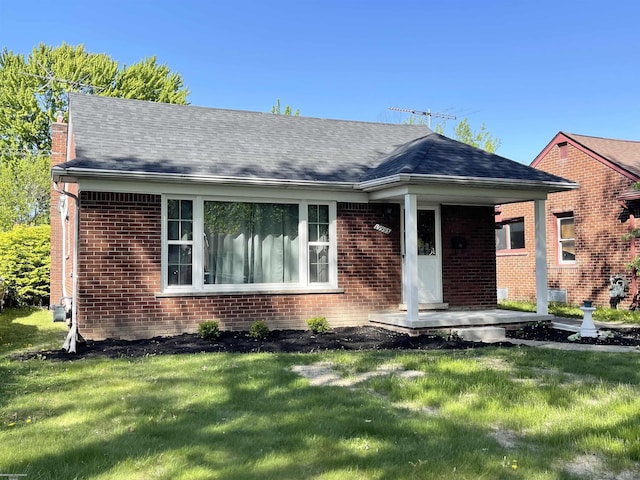 19993 Woodmont St, Harper Woods, MI 48225 - view of front of house with a front lawn, brick siding, and a porch