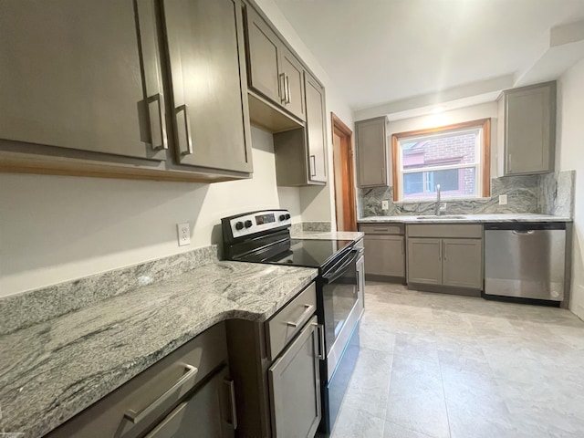 19993 Woodmont St, Harper Woods, MI 48225 - kitchen featuring stainless steel appliances, a sink, light stone counters, and gray cabinets