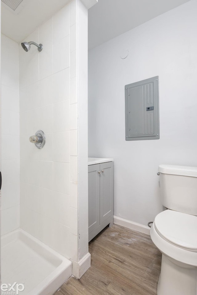 3168 Herbell Dr, Waterford, MI 48328 - bathroom featuring electric panel, wood finished floors, a stall shower, toilet, and baseboards