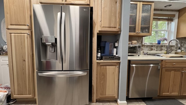 7741 White Birch St, Farwell, MI 48622 - kitchen featuring appliances with stainless steel finishes, decorative backsplash, glass insert cabinets, light countertops, and a sink