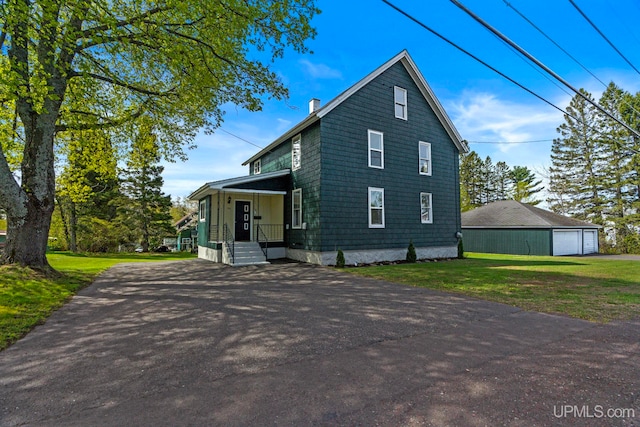 336 Fulton St, Mohawk, MI 49950 - view of front of property featuring an outbuilding, a front lawn, a detached garage, and asphalt driveway