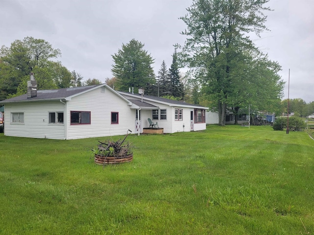 5523 Red Oak Rd, Beaverton, MI 48612 - back of house with a lawn and a chimney