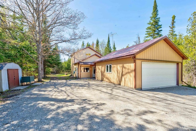 3159 N State Highway M94, Manistique, MI 49854 - view of side of home with metal roof and a detached garage