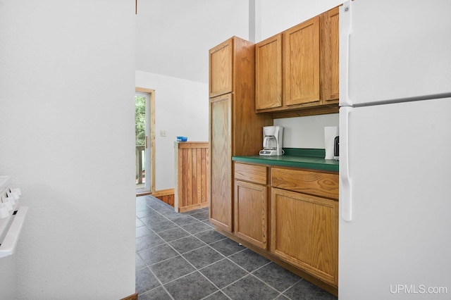 8413 Gay Park Rd, Lake Linden, MI 49945 - kitchen featuring freestanding refrigerator, dark tile patterned floors, and brown cabinetry
