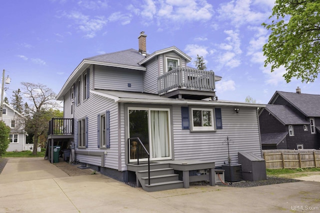 120 E Prospect St, Marquette, MI 49855 - back of house featuring a balcony, a chimney, central AC unit, and a shingled roof
