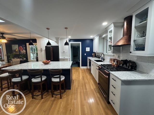28800 Old N River Rd, Harrison Twp, MI 48045 - kitchen with stainless steel appliances, light wood finished floors, backsplash, a sink, and white cabinets