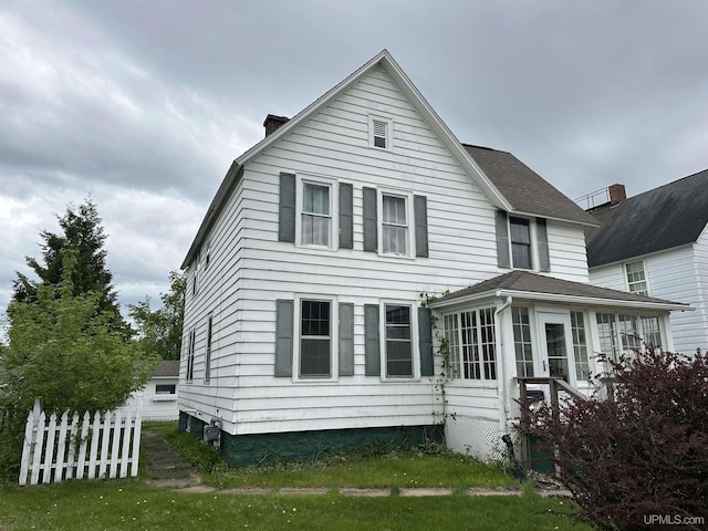 1217 S Kimberly Ave, Iron Mountain, MI 49801 - rear view of house featuring a chimney and a sunroom