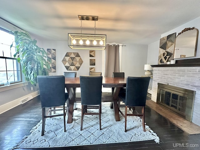 1217 S Kimberly Ave, Iron Mountain, MI 49801 - dining area with hardwood / wood-style flooring, a brick fireplace, and baseboards