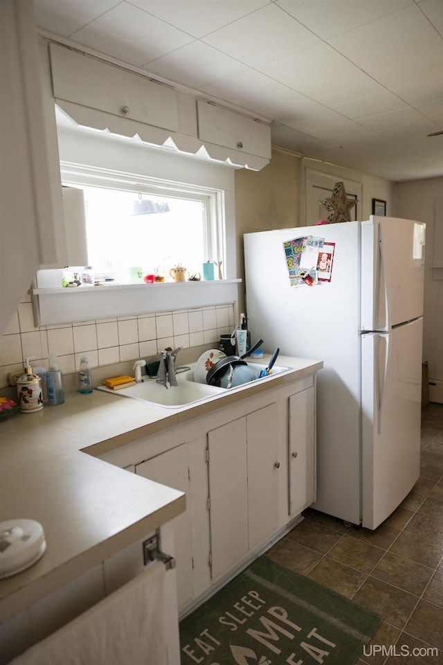 3110 County Road Fd Rd, Champion, MI 49814 - kitchen with freestanding refrigerator, tasteful backsplash, light countertops, white cabinets, and a sink