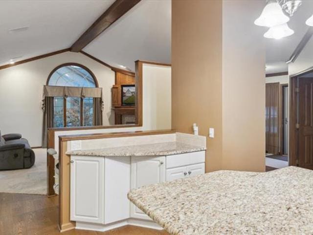 5631 W Spring Knoll Dr, Bay City, MI 48706 - kitchen with wood finished floors, white cabinets, light stone countertops, and open floor plan