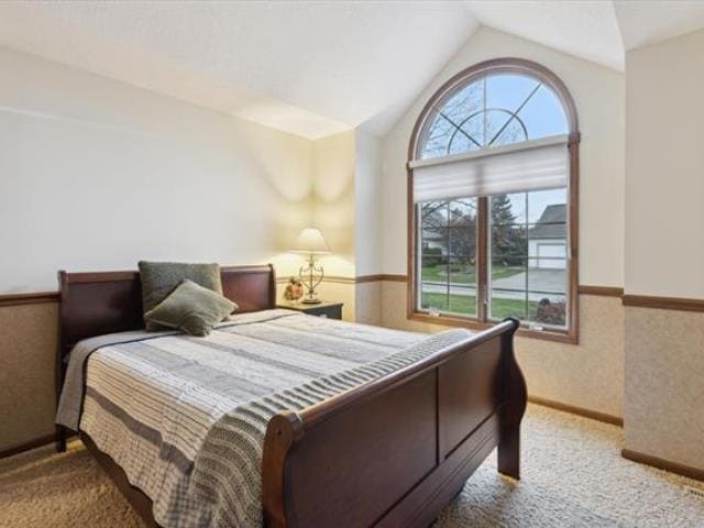 5631 W Spring Knoll Dr, Bay City, MI 48706 - bedroom featuring carpet floors, vaulted ceiling, and wainscoting