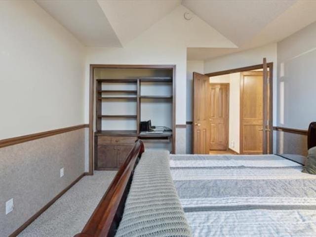 5631 W Spring Knoll Dr, Bay City, MI 48706 - bedroom with carpet flooring, lofted ceiling, and wainscoting