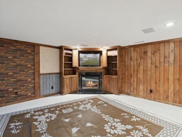 5631 W Spring Knoll Dr, Bay City, MI 48706 - unfurnished living room with a glass covered fireplace, wooden walls, and recessed lighting