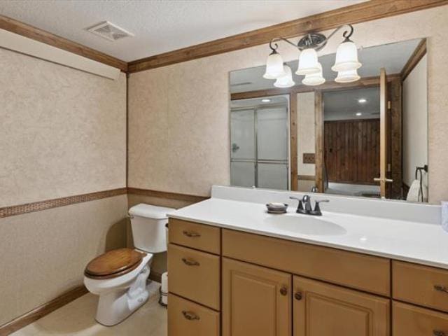 5631 W Spring Knoll Dr, Bay City, MI 48706 - bathroom featuring toilet, vanity, crown molding, and a chandelier