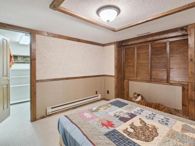 5631 W Spring Knoll Dr, Bay City, MI 48706 - carpeted bedroom with baseboard heating and a textured ceiling