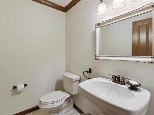 5631 W Spring Knoll Dr, Bay City, MI 48706 - half bath with crown molding, toilet, baseboards, and a sink